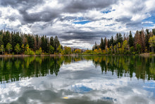 Load image into Gallery viewer, Dramatic clouds and forest reflected on Big East Lake in Utah, creating a perfect mirror-like scene.