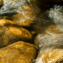 Load image into Gallery viewer, A mesmerizing dance of waves gently caressing the large rocks at the lake's edge. Photography by Ana Sosa