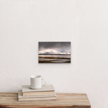 Load image into Gallery viewer, "Winter's Embrace 8" x 12" - Intimate beauty on a white wall, the piece's size compared to books and a mug, creating a cozy corner."