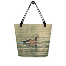 Load image into Gallery viewer, Tote bag with all-over print of a duck swimming in the reflection of the green water, hanging on the wall