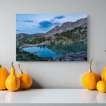 Load image into Gallery viewer, A picture title Cloudy Sky over Cecret Lake. The sky and mountains reflecting on the water showing cool temperture, display over a shelf contrasting with orange punkins