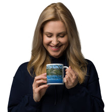 Load image into Gallery viewer, A woman with a white glossy 11 oz mug with Mantua Reservoir image. Handle on right