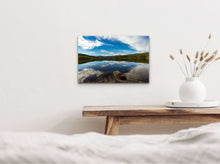 Load image into Gallery viewer, "'Tranquil Oasis' 16" x 24" - Gracing a white wall, above a table with a Bogo-style vase for size comparison, creating a harmonious display."
