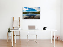 Load image into Gallery viewer, "'Tranquil Oasis' 24" x 36" - Enhancing a home office with a white wall, a table holding a camera, a green plant in a white planter, and a wooden floor, creating a serene workspace."