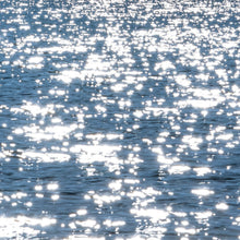 Load image into Gallery viewer, Radiant silver sparkles in the calm blue waters, reflection of the sun&#39;s shine in the water captured in a photograph by Ana Sosa.
