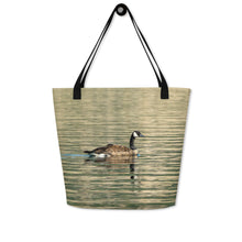 Load image into Gallery viewer, Tote bag with all-over print of a duck swimming in the reflection of the green water, hanging on the wall
