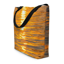 Load image into Gallery viewer, A tote bag seen from the side with a photo of an orange reflection printed on a large bag.
