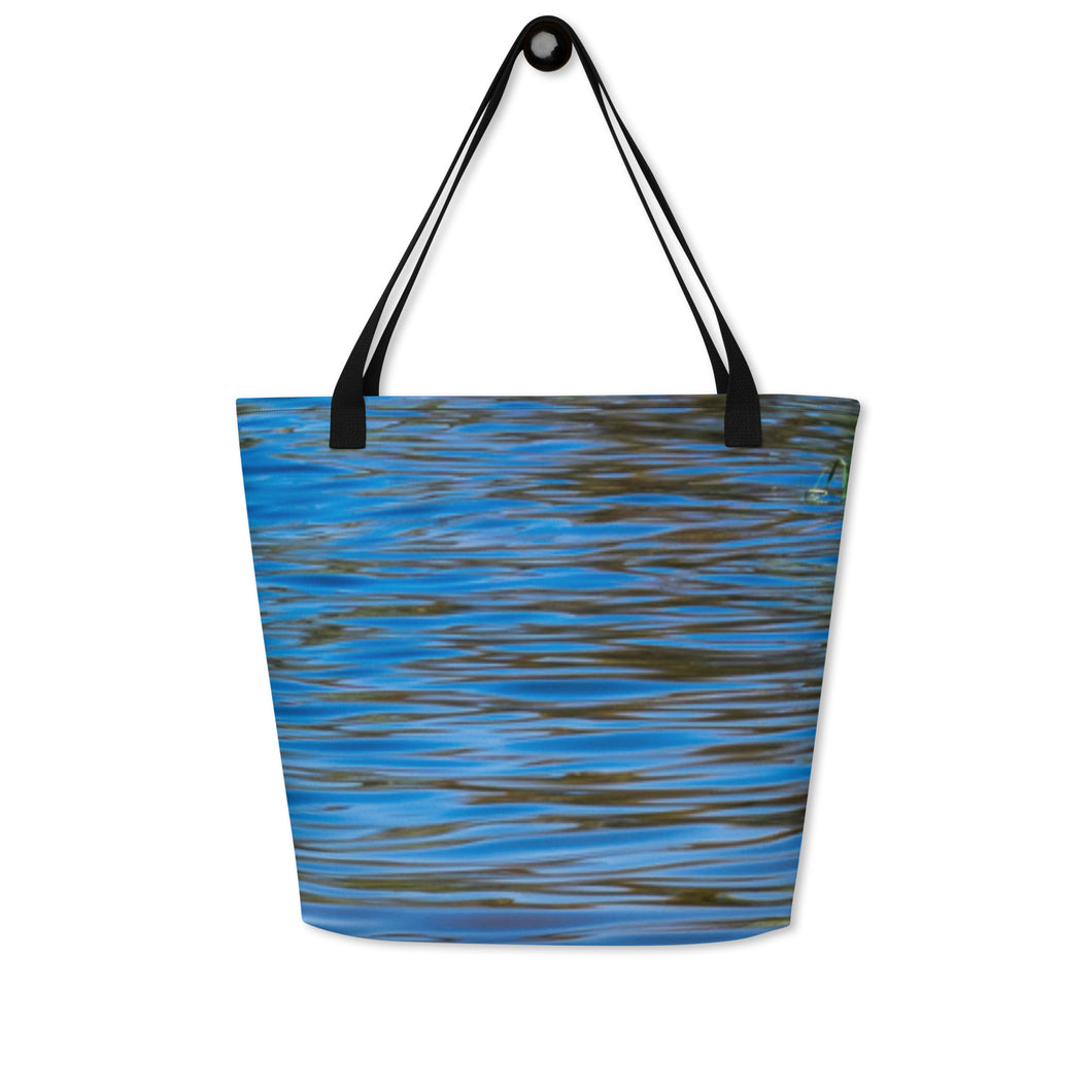 All over print large tote bag with pocket, front side printed with picture of blue water reflections. Hanging on the wall