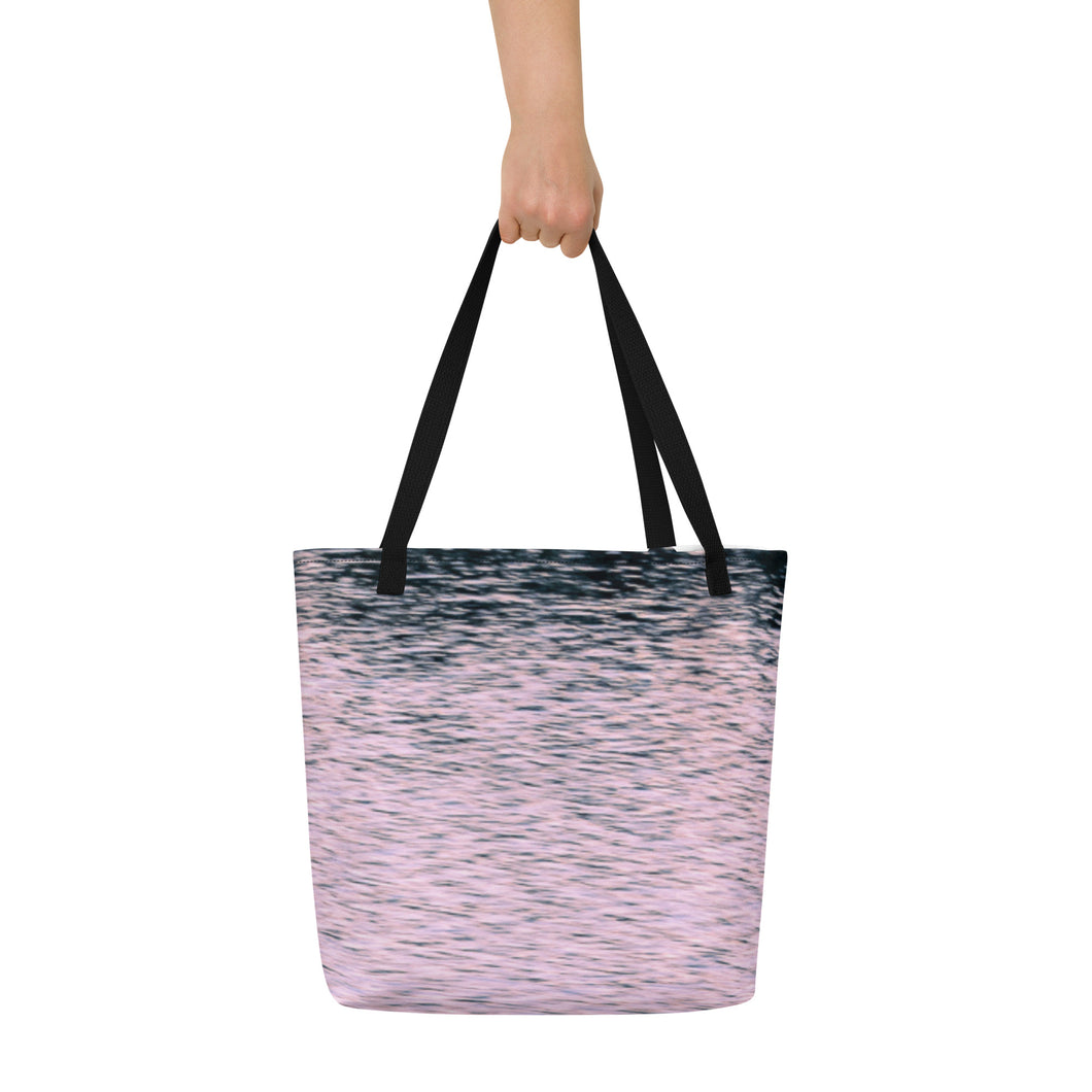 A tote bag printed with pink tones of sunset reflections. Versatile with black highlights. A modern beach bag.