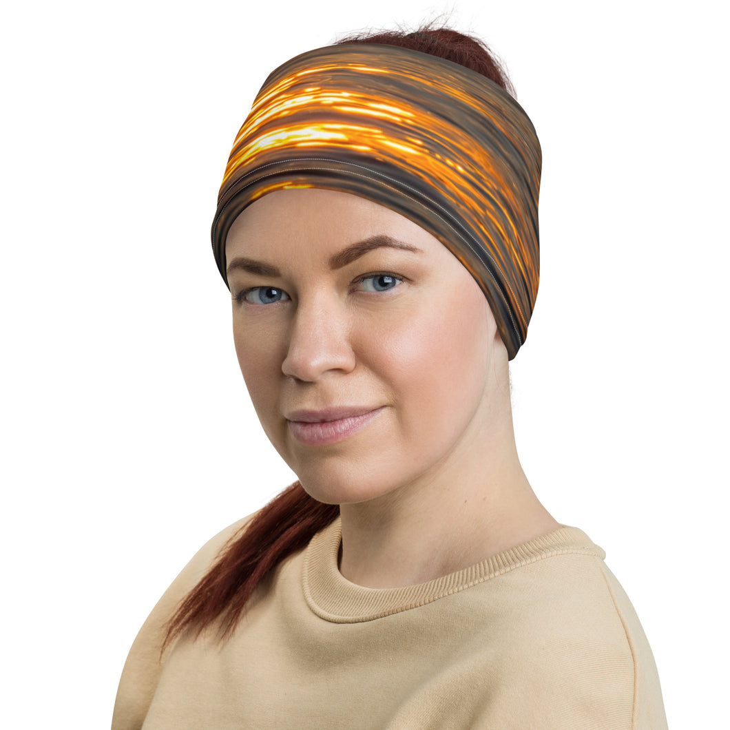A woman wearing a neck gaiter. All over print orange, left side.