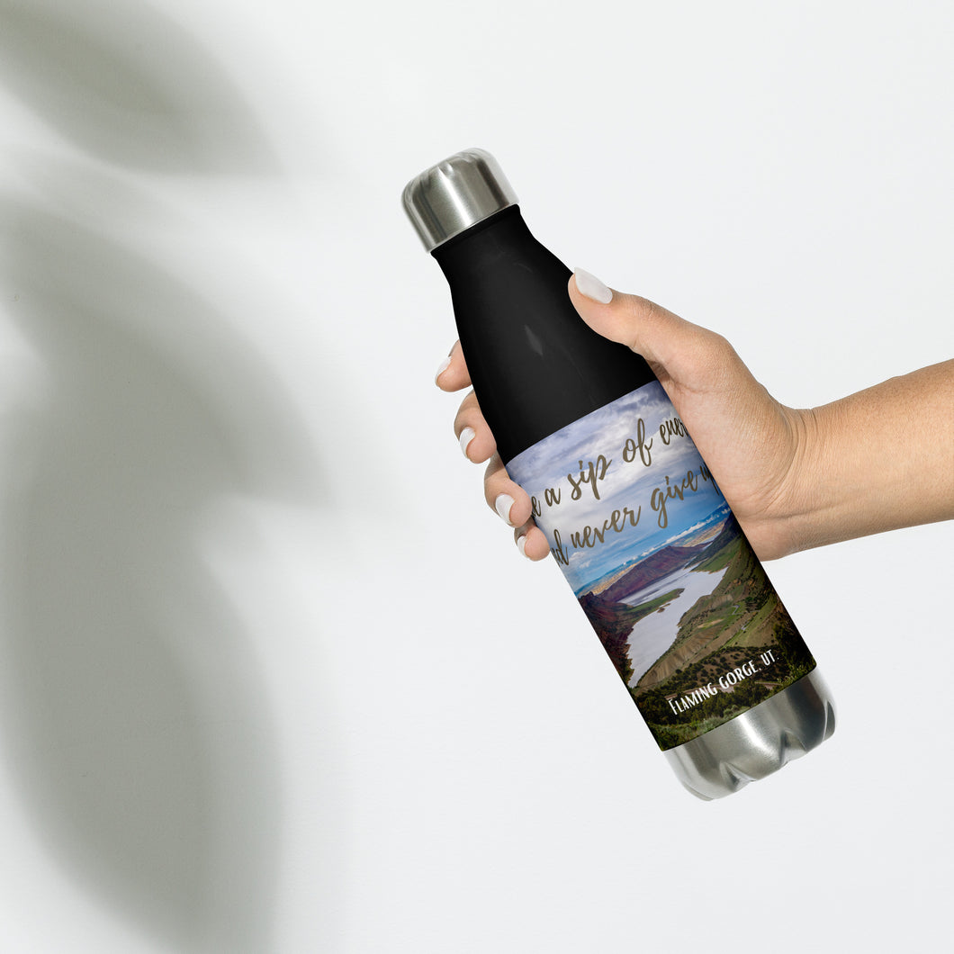 Stainless steel water bottle black 17 oz. On hand, front side view with Flaming Gorge Reservoir and 'take a sip of energy and never give-up' printed.