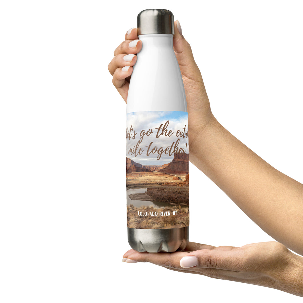 Stainless steel water bottle white 17 oz. On hand, front side view with Colorado River and Let's go to the extra mile together printed.