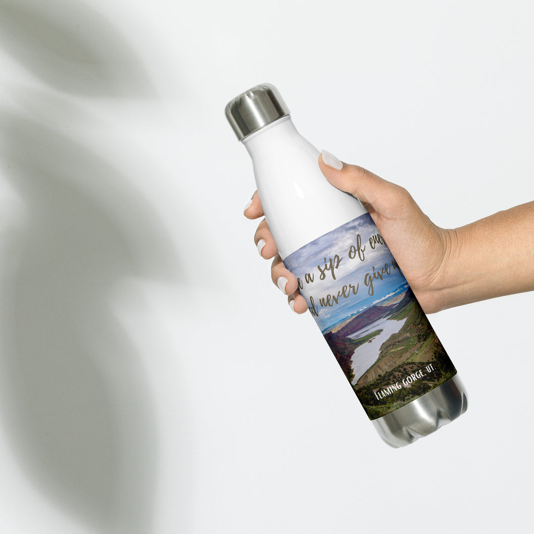 Stainless steel water bottle white 17 oz. On hand, front side view with Flaming Gorge Reservoir and 'take a sip of energy and never give-up' printed.