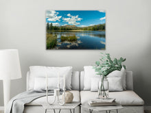 Load image into Gallery viewer, &#39;Oasis of Crystalline Water&#39; - 24&quot;x36&quot; in a contemporary living room with white furniture, vases, candelabra, and a modern lamp.
