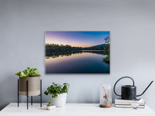 Load image into Gallery viewer, •	&quot;&#39; Sun&#39;s Rays Kiss’ 16&quot; x 24&quot; - Enhancing a white wall, above a wooden table with books and a small potted plant, showcasing the relationship between size and surroundings.&quot;
